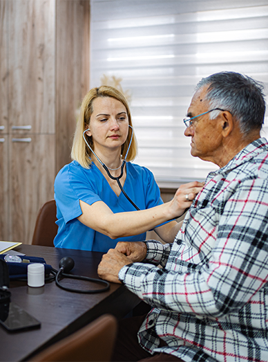 Female clinician assessing an older male patient with a stethoscope at Botanic Ridge Doctors